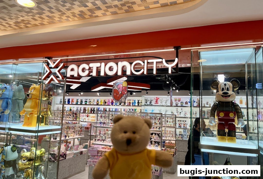 ActionCity Bugis Junction shop interior showcasing collectible toys and figures, with a teddy bear in the foreground.