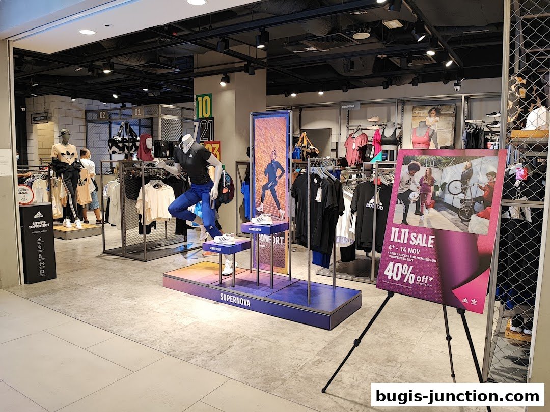 Interior of an Adidas store featuring mannequins, clothing racks, and a sale advertisement.
