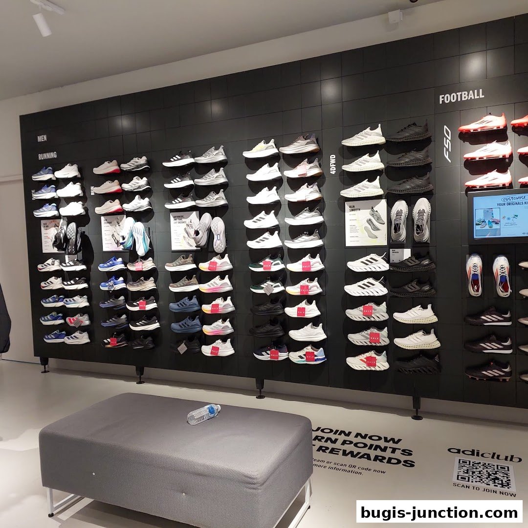 Interior view of an Adidas store showcasing a wide selection of athletic footwear organized by category.