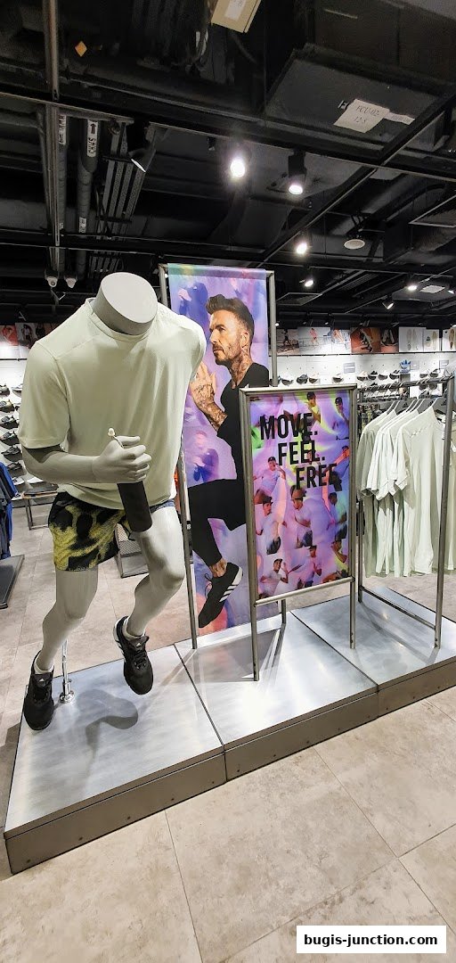 Mannequin in Adidas sportswear with David Beckham poster and clothing racks.