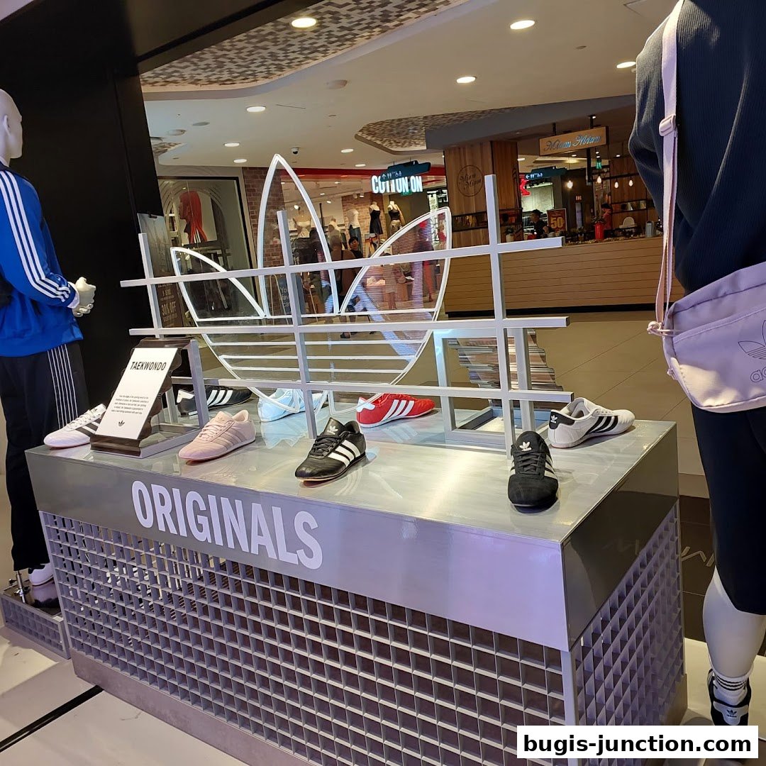 Adidas Originals display featuring various shoe models and a large trefoil logo.