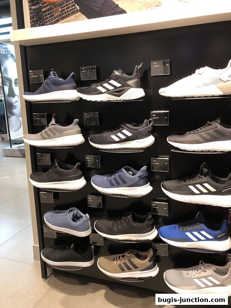 A display wall showcasing a variety of Adidas running shoes in different colors and styles.