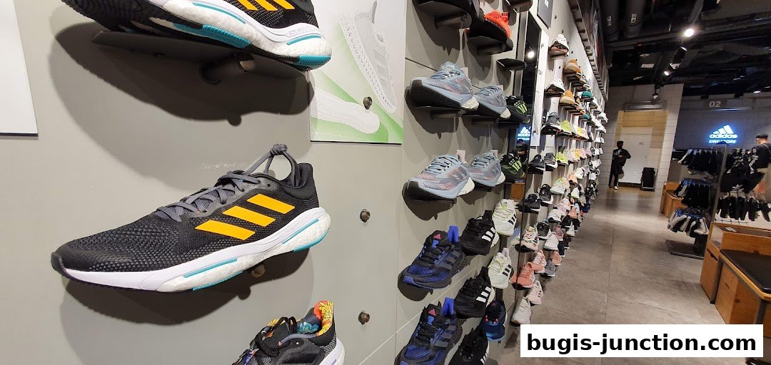Interior view of an Adidas store showcasing a wide variety of athletic shoes displayed on shelves.