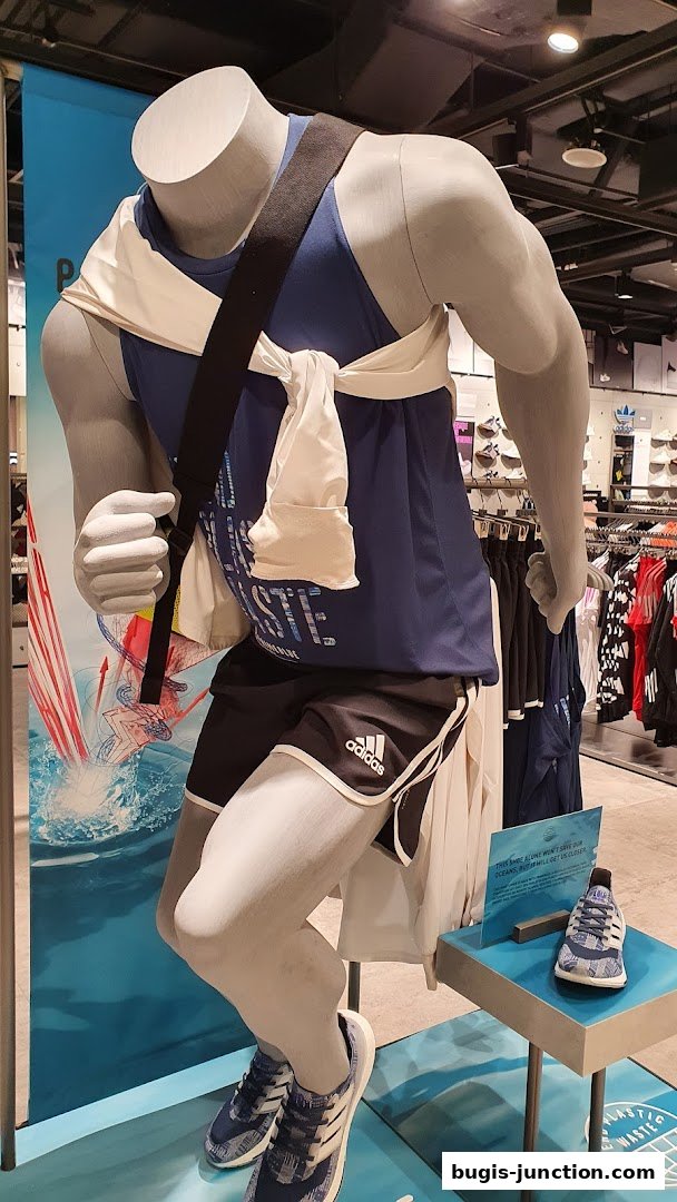 Mannequin dressed in Adidas athletic wear, showcasing a new shoe and promotional material.