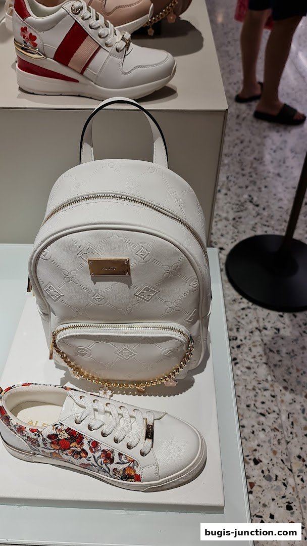 ALDO store display featuring white sneakers and a white backpack with gold accents.