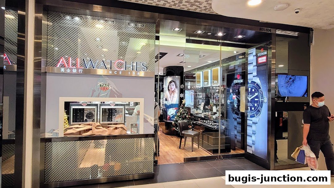 The exterior of a modern watch shop displaying various watch brands and a festive Christmas tree.