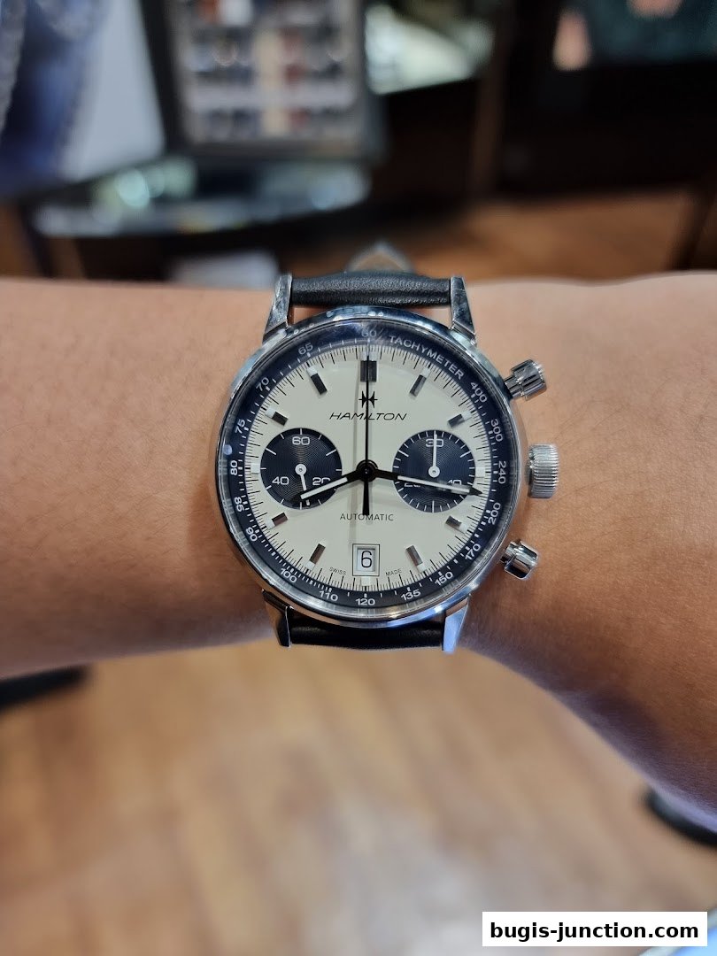 A close-up shot of a Hamilton automatic watch with a black leather strap on a wrist.