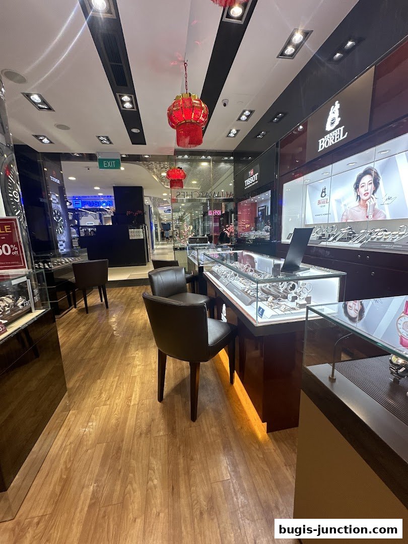 Interior view of a watch shop with display cases and seating.