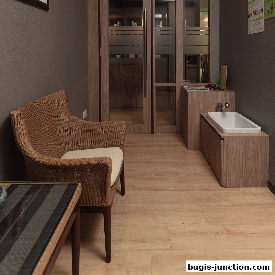 A waiting area with a wicker chair and a sink area in a spa or salon.