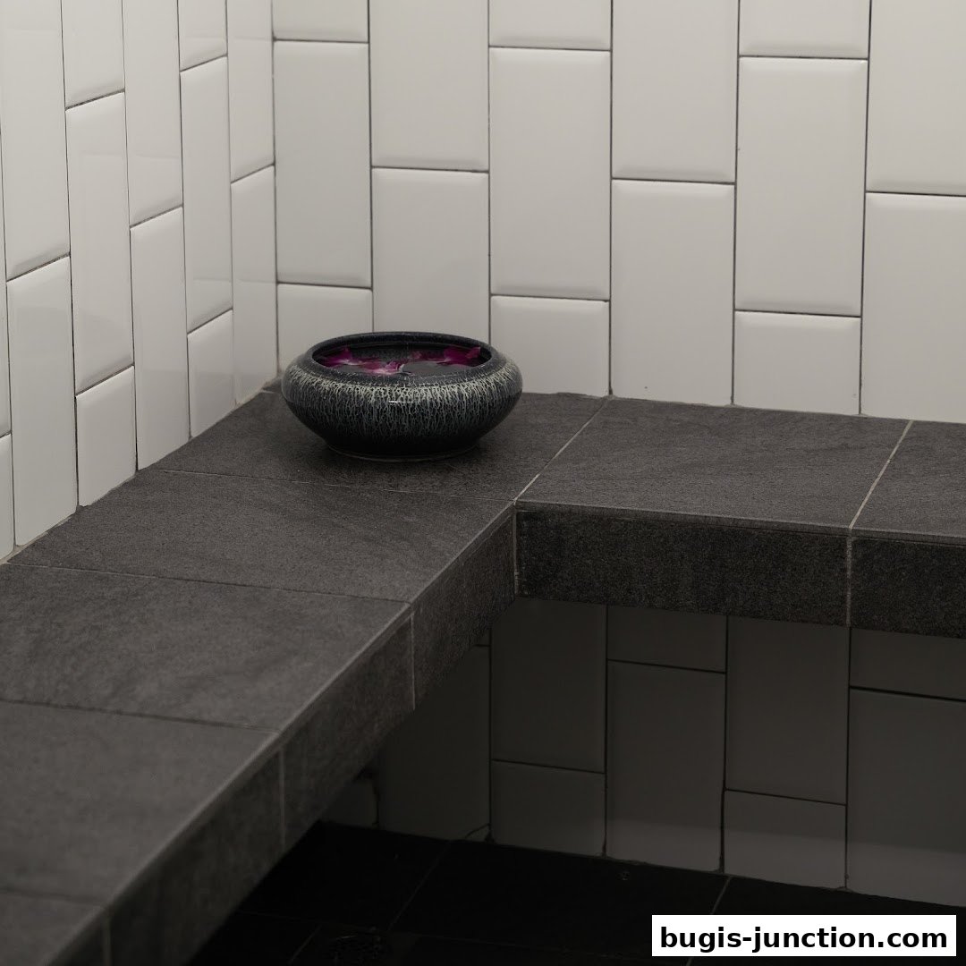 A decorative bowl filled with water and petals sits on a stone bench in a tiled room.