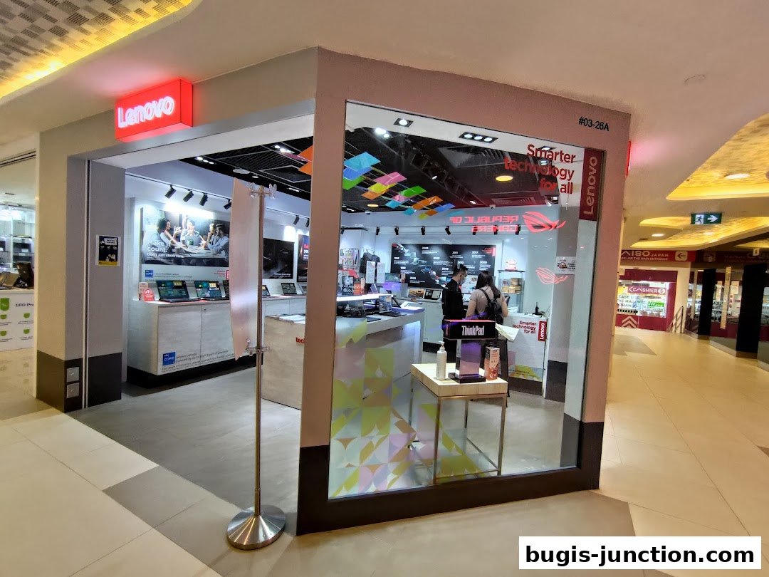 The entrance to a modern Lenovo electronics store showcasing laptops and technology.