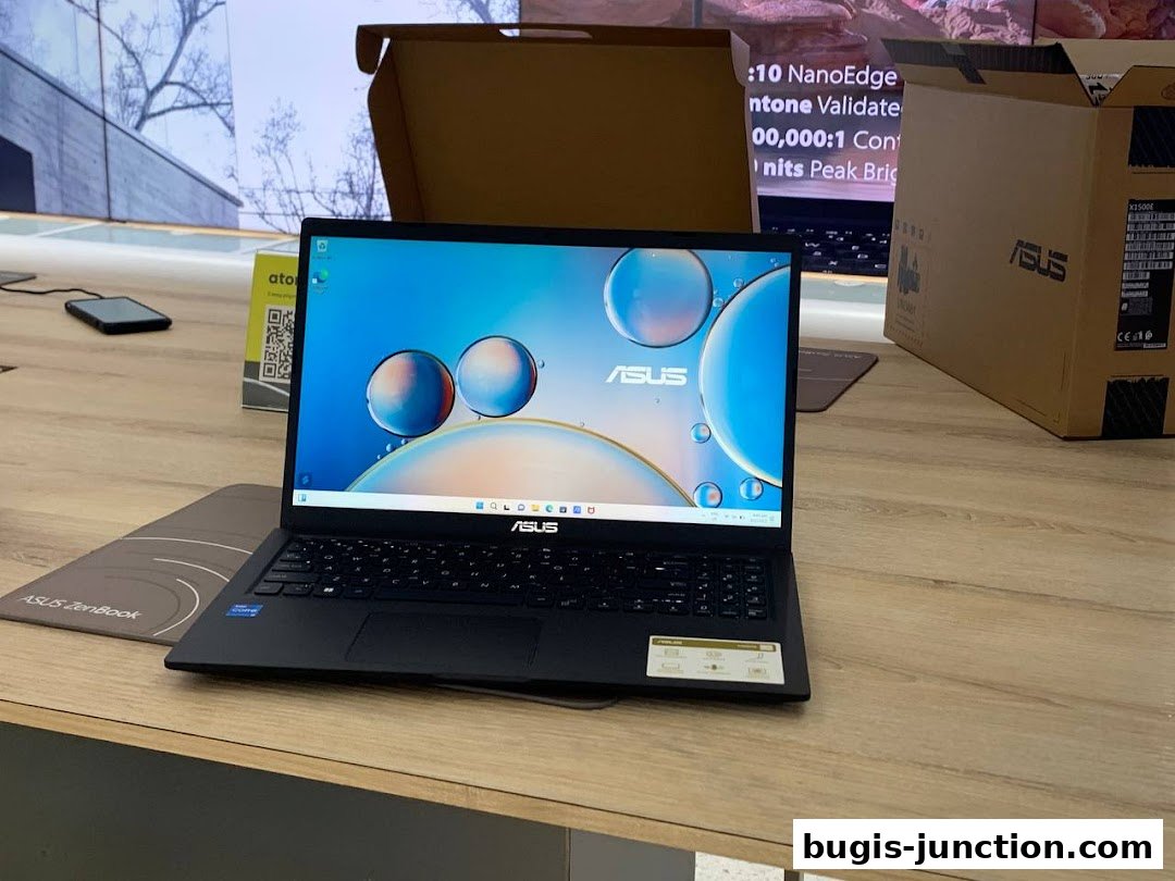 An ASUS laptop is displayed on a wooden counter with product boxes in the background.