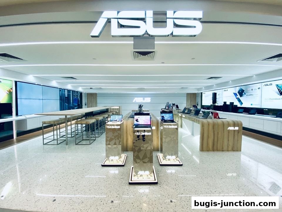 Interior of an ASUS Exclusive Store showcasing laptops and a long communal table with seating.