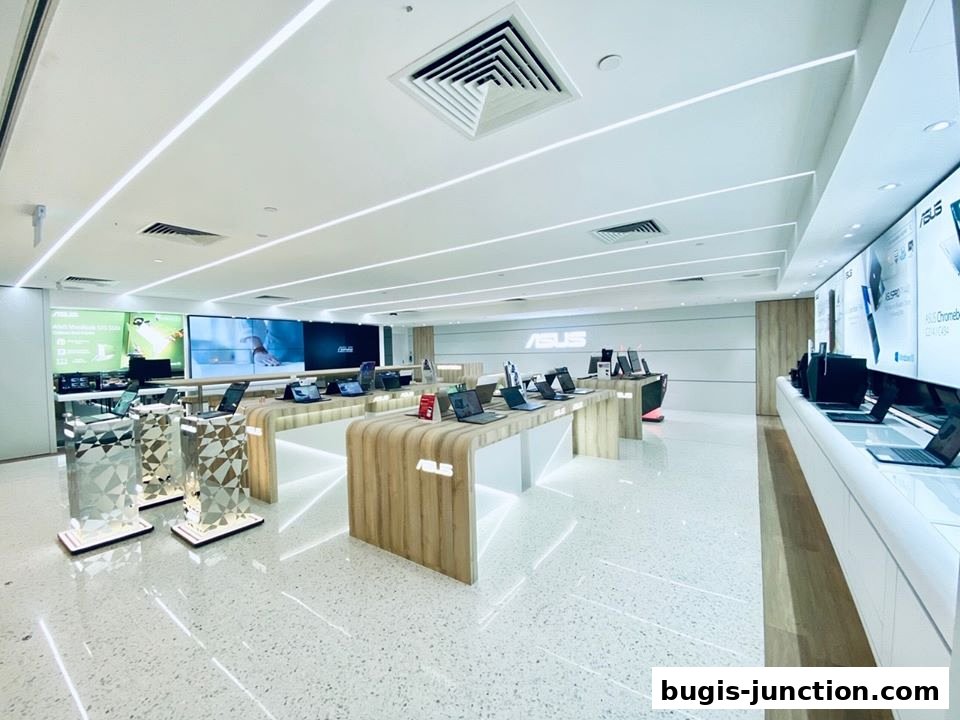 Interior of a modern ASUS store showcasing laptops and displays on sleek stands.
