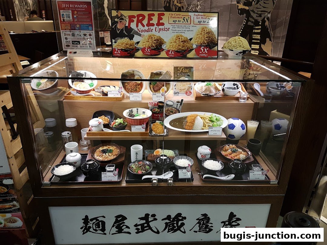 A display case showcasing realistic food models of Japanese dishes, including ramen and curry.