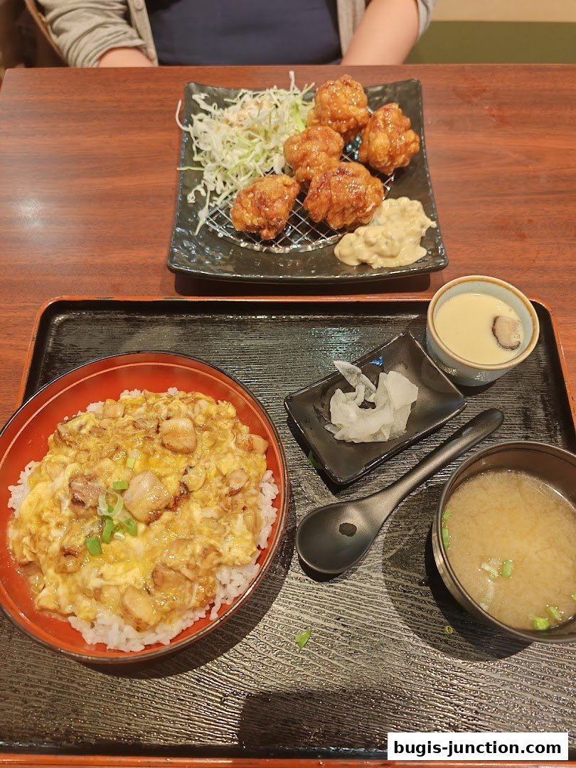 A Japanese meal featuring chicken karaage, donburi, miso soup, and chawanmushi.