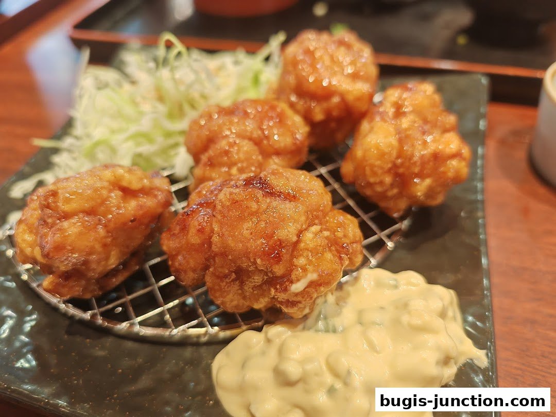 Crispy Japanese fried chicken served with shredded cabbage and dipping sauce.