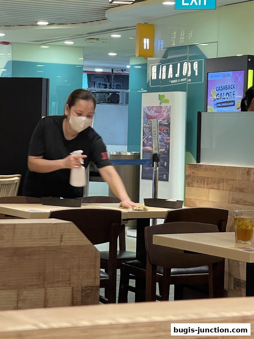 A staff member cleans a table at a Japanese restaurant.