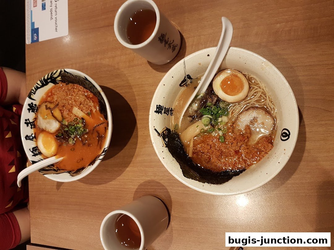 Two bowls of ramen and two cups of tea on a wooden table.