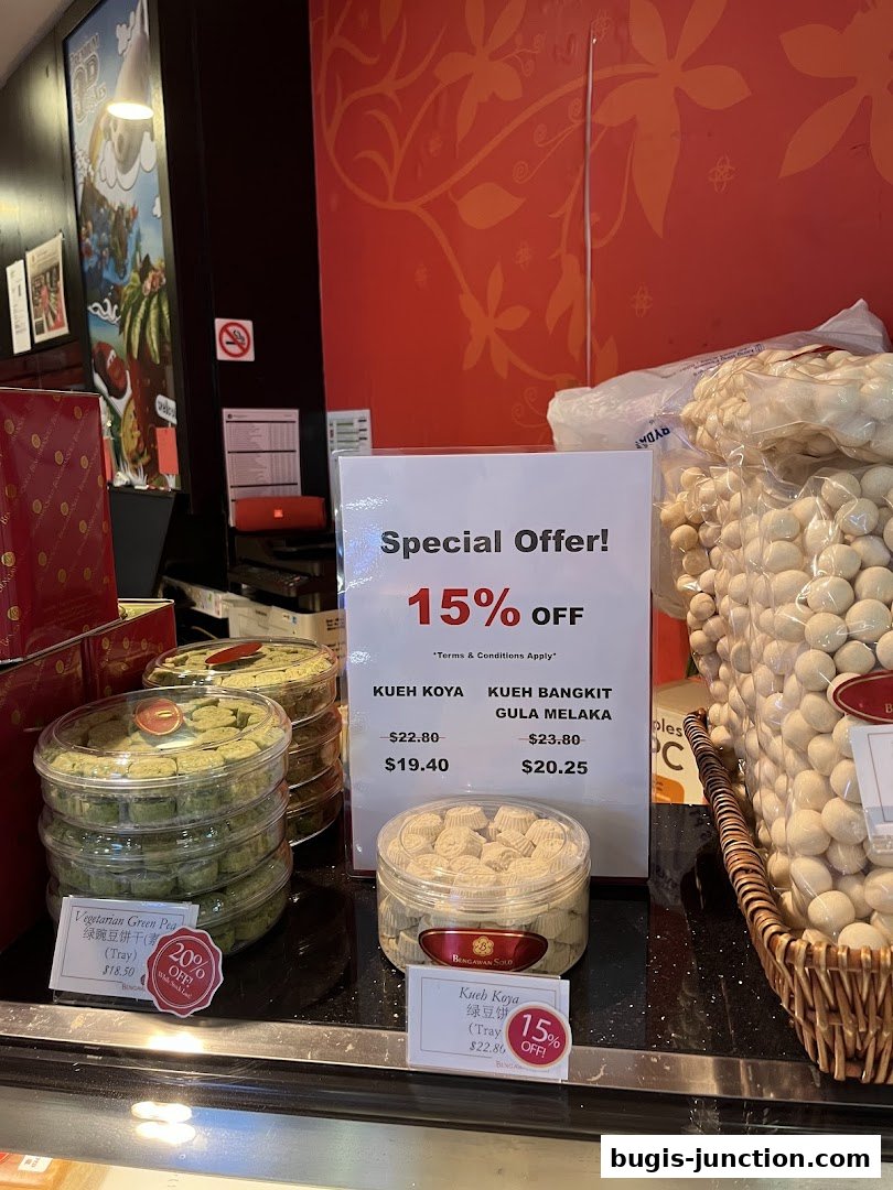 A display of assorted kueh and snacks with a special 15% off offer.