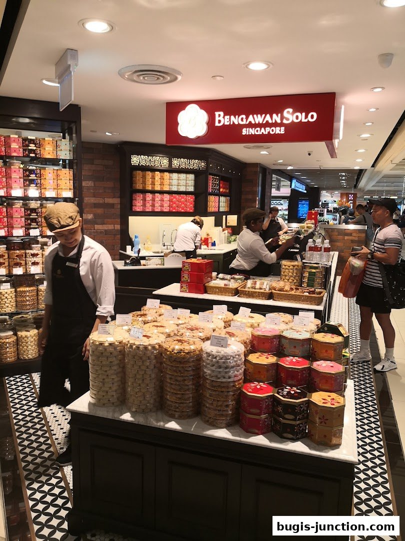 A shop interior displaying a variety of cookies and traditional snacks in decorative tins and jars.
