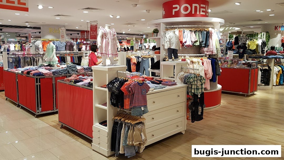 A brightly lit children's clothing store with racks of colorful apparel and mannequins.
