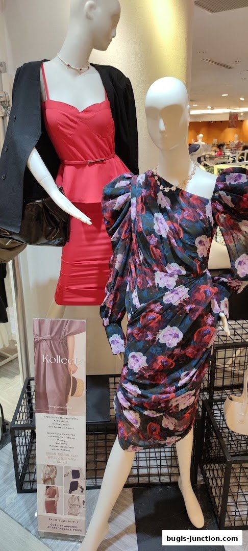 Mannequins display fashionable dresses and accessories in a retail store.