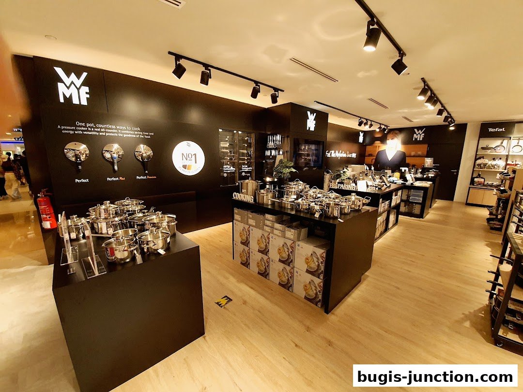 Interior view of a kitchenware store showcasing various pots and pans, with branding visible.