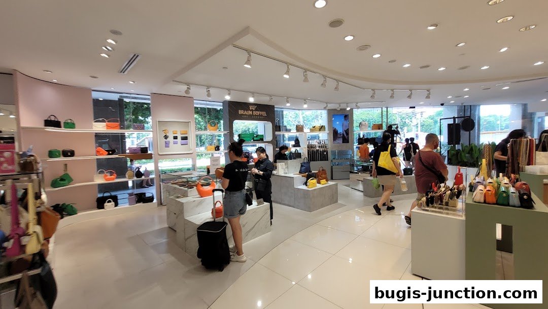 Interior view of a stylish handbag store with various bags displayed on shelves and stands.