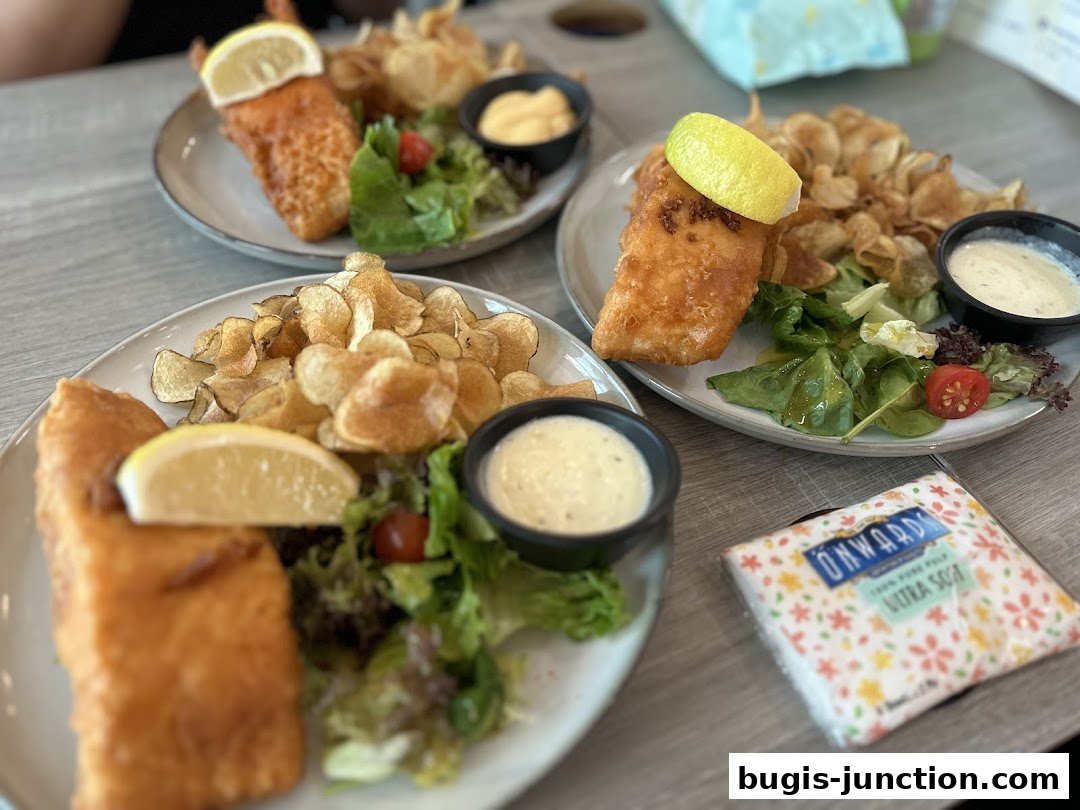 Three plates of battered fish and chips with salad and dipping sauce.