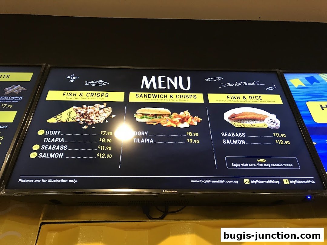 A digital menu board displaying various fish and crisps, sandwiches, and fish and rice options.
