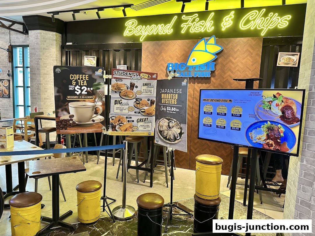 A restaurant interior with promotional posters and a digital menu displaying food items.