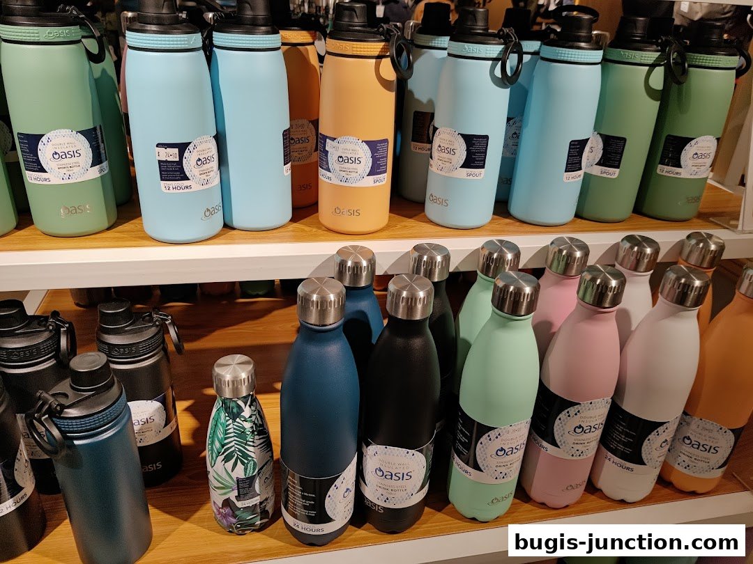 A display of colorful Oasis brand water bottles on shelves, in various sizes and colors.