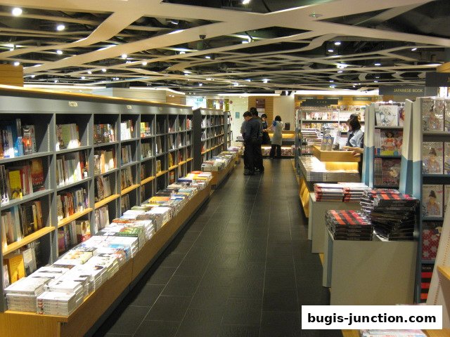 Interior view of a spacious bookstore with shelves full of books and customers browsing.