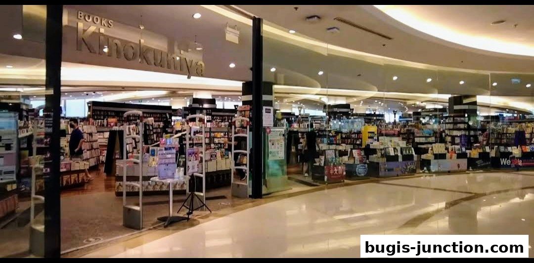 The entrance and interior of a large bookstore, Books Kinokuniya, filled with shelves of books.