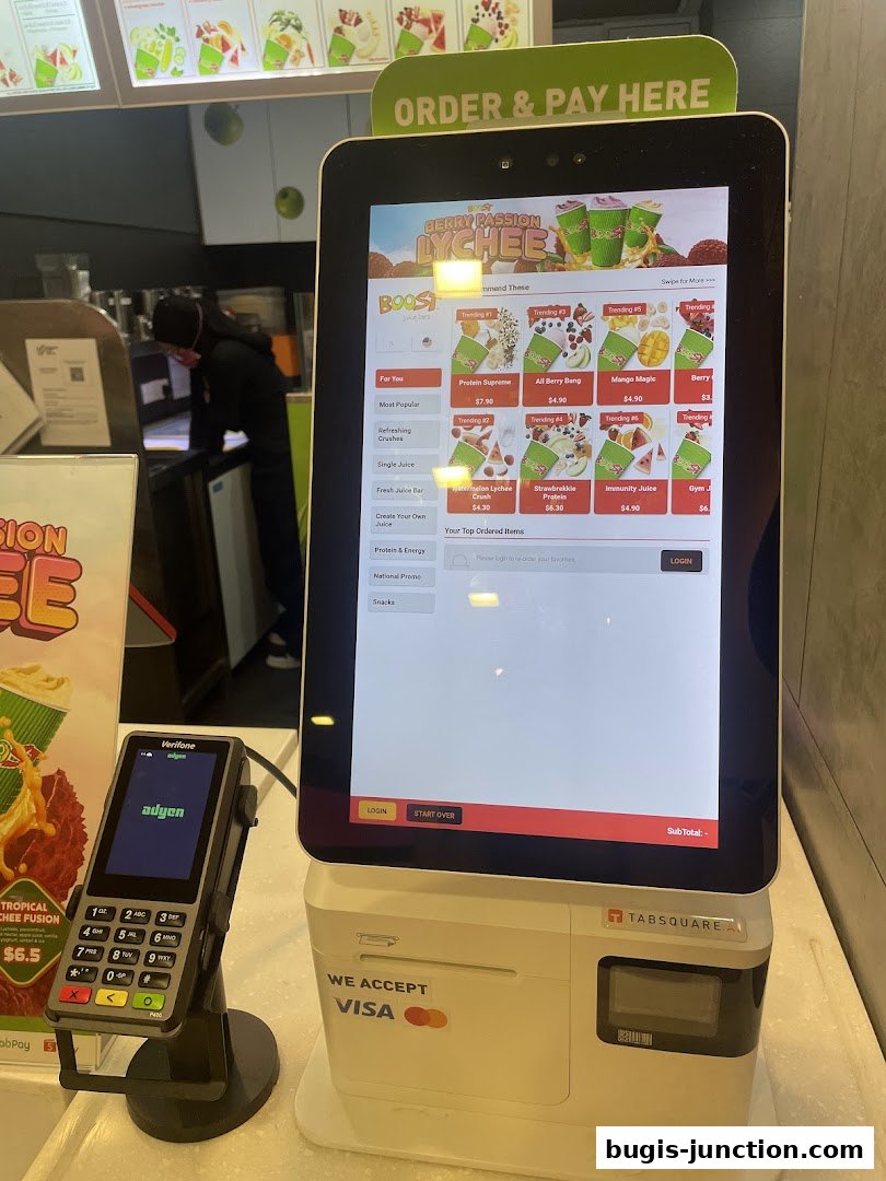A self-order kiosk at Boost Juice displaying menu items and payment options.