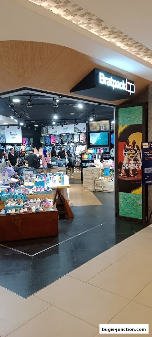 The entrance of Bratpack Bugis shop, showcasing various backpacks and footwear.