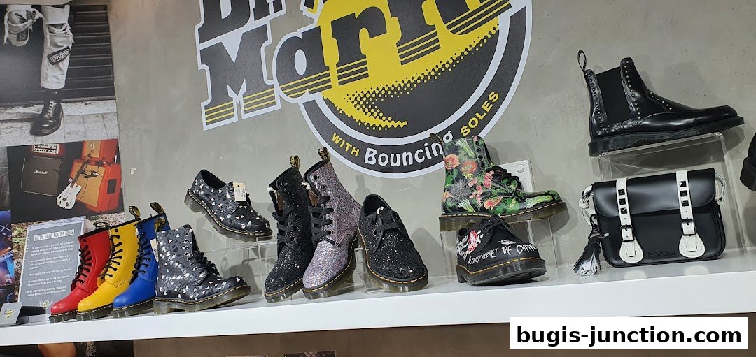 A display of various Dr. Martens boots and shoes, including colorful and patterned styles, and a handbag.