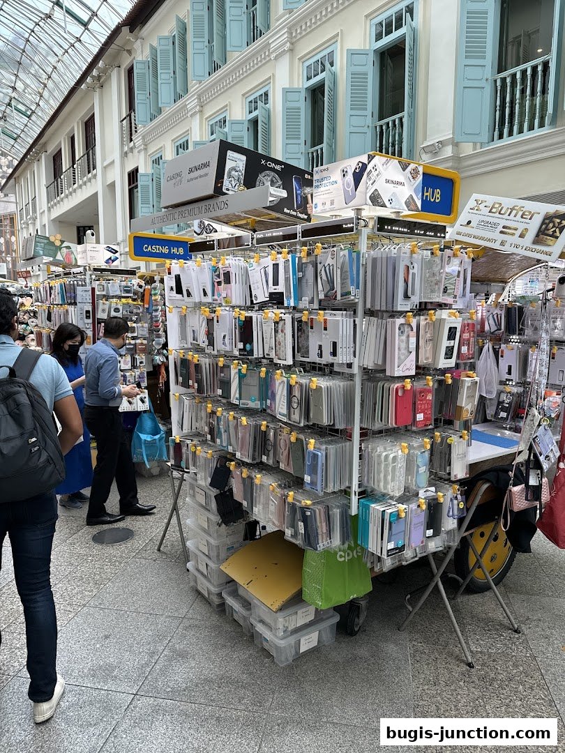 A stall displaying a wide variety of phone cases and accessories, with people browsing.