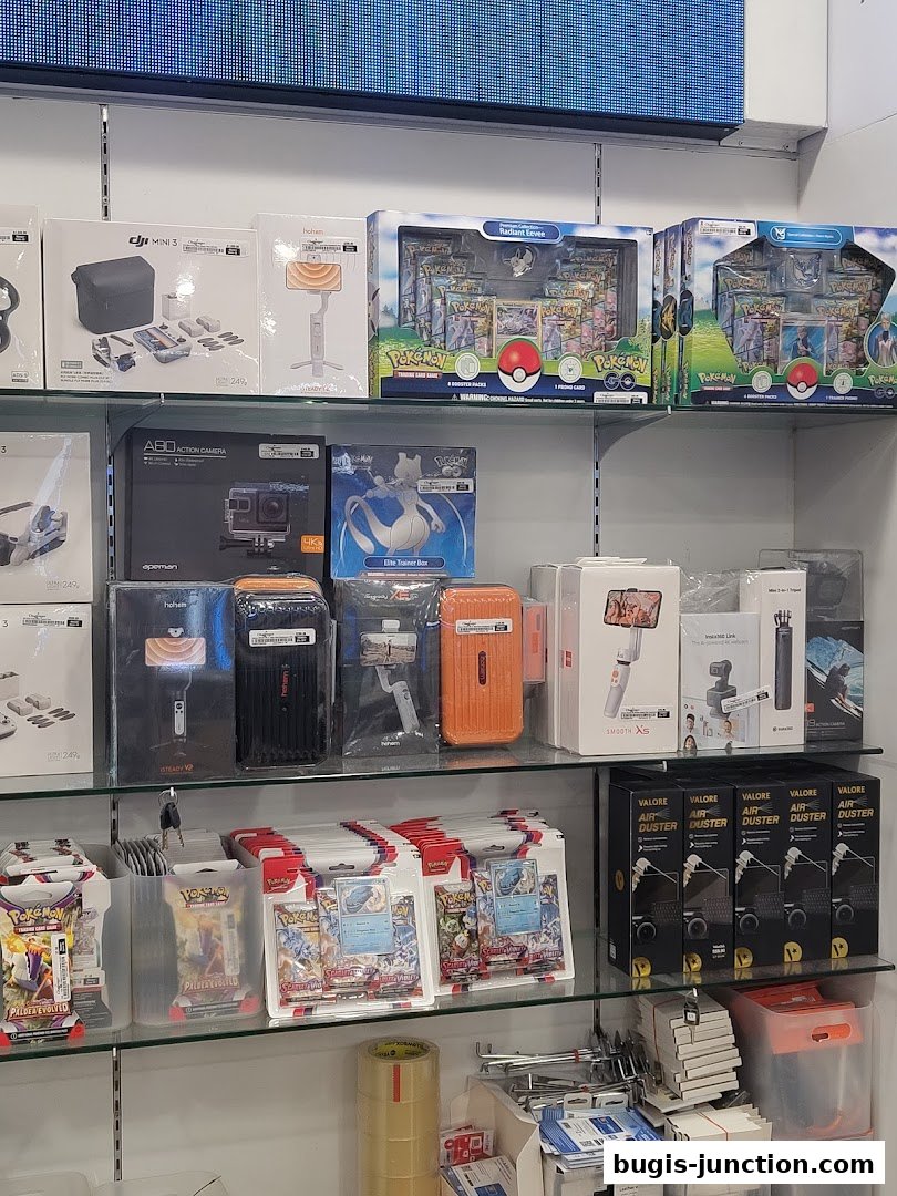 Shelves stocked with electronics, including camera accessories, gimbals, and Pokémon trading cards.