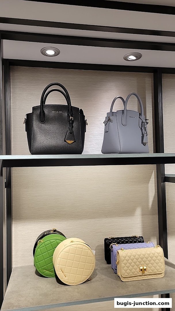 A display of various Charles & Keith handbags in different styles and colors on shelves.