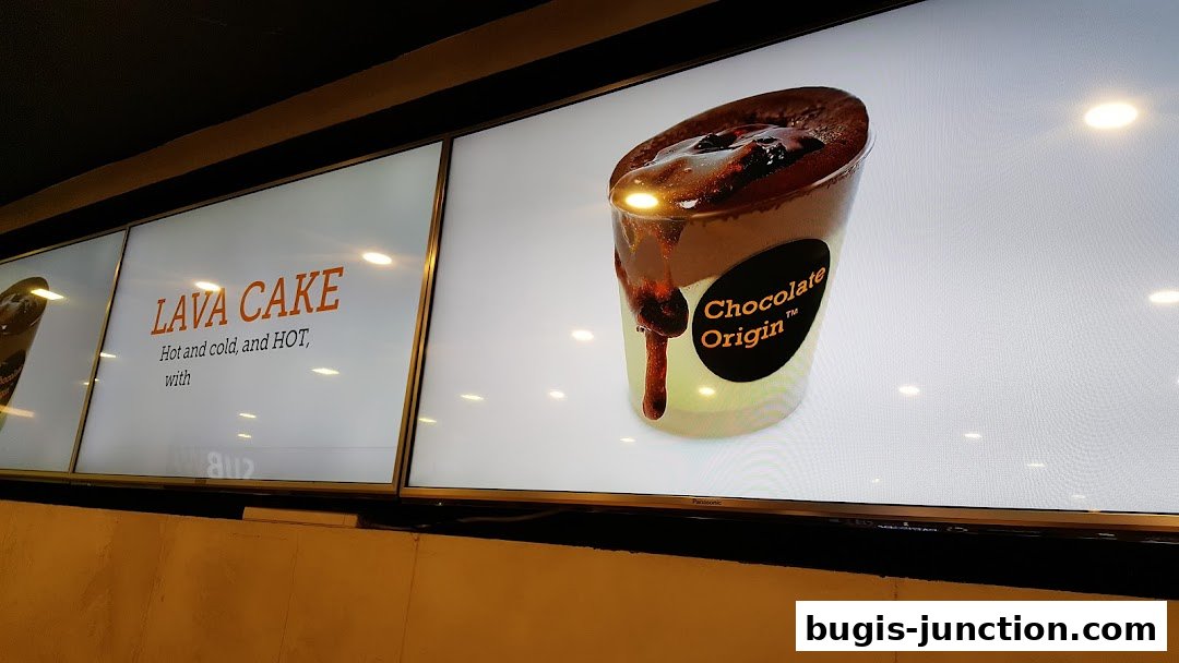 A display board showcasing a decadent chocolate lava cake from Chocolate Origin.