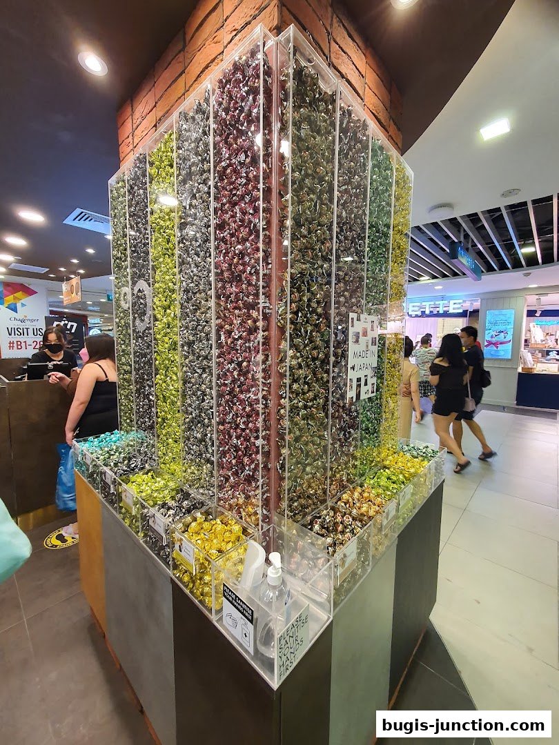 A large display of colorful wrapped chocolates in a retail store.