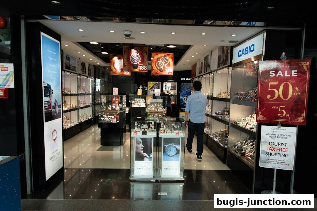 A man walks into a brightly lit watch store with displays of watches and a sale sign.