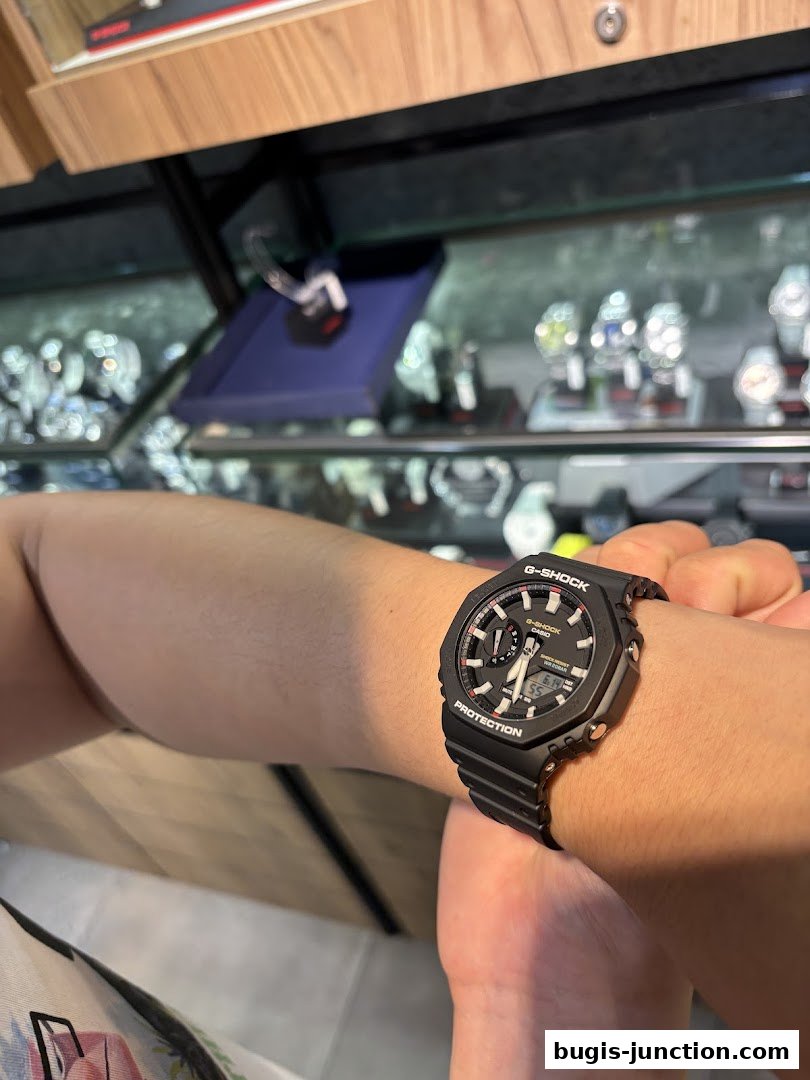 A person wearing a black G-Shock watch with a display showing time.