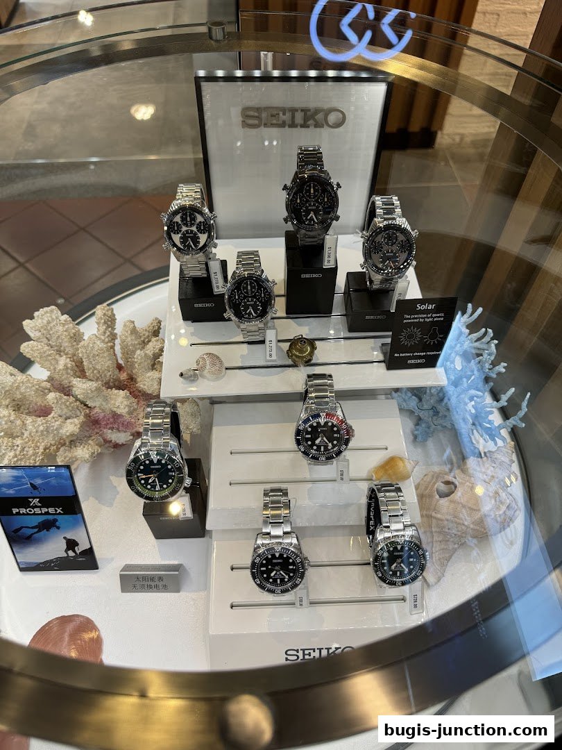 A display case showcasing various Seiko watches, including dive and chronographs.