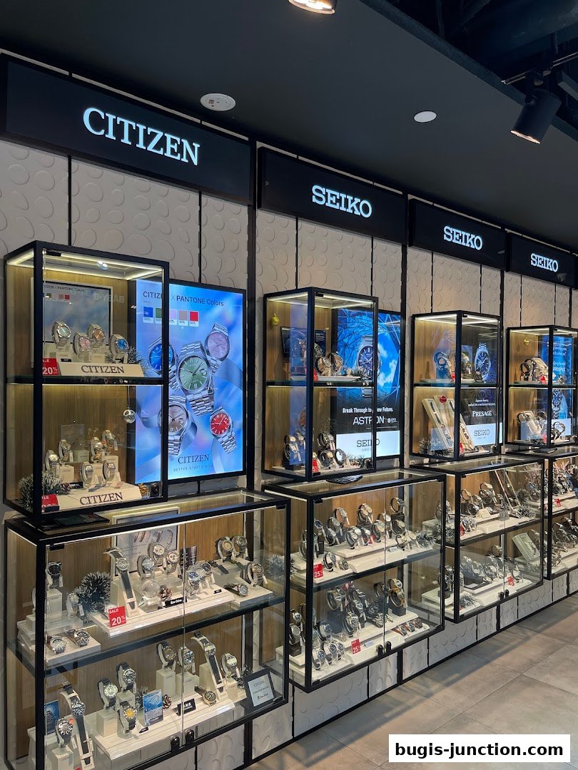 A well-lit display of Citizen and Seiko watches in glass cabinets.