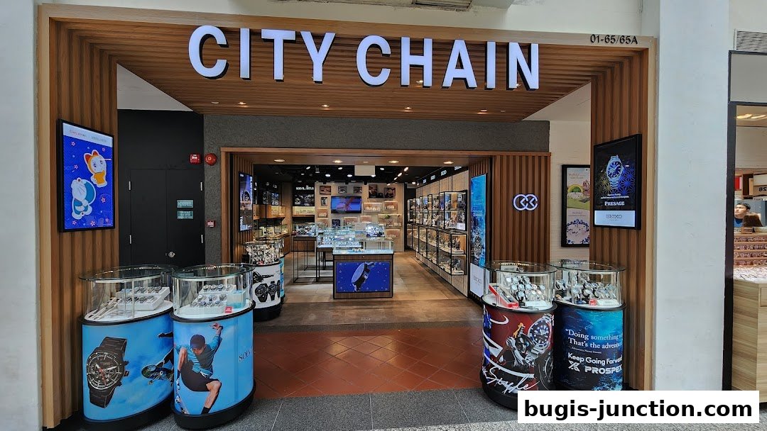 The entrance of a City Chain watch store, showcasing display cases with watches and promotional posters.