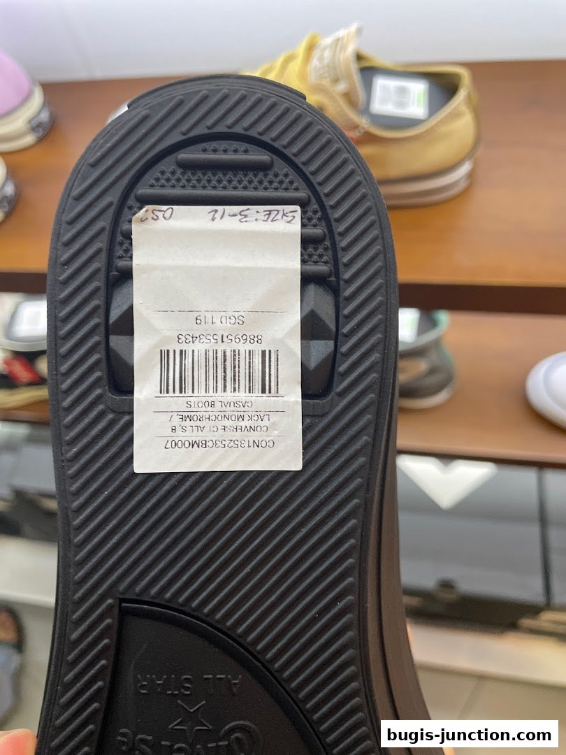 Close-up of a Converse shoe sole with a price tag and size information.
