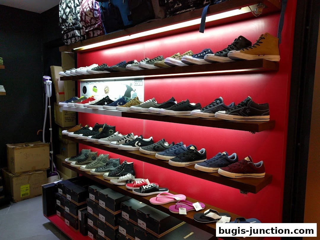 A display of Converse sneakers and accessories on shelves in a retail store.